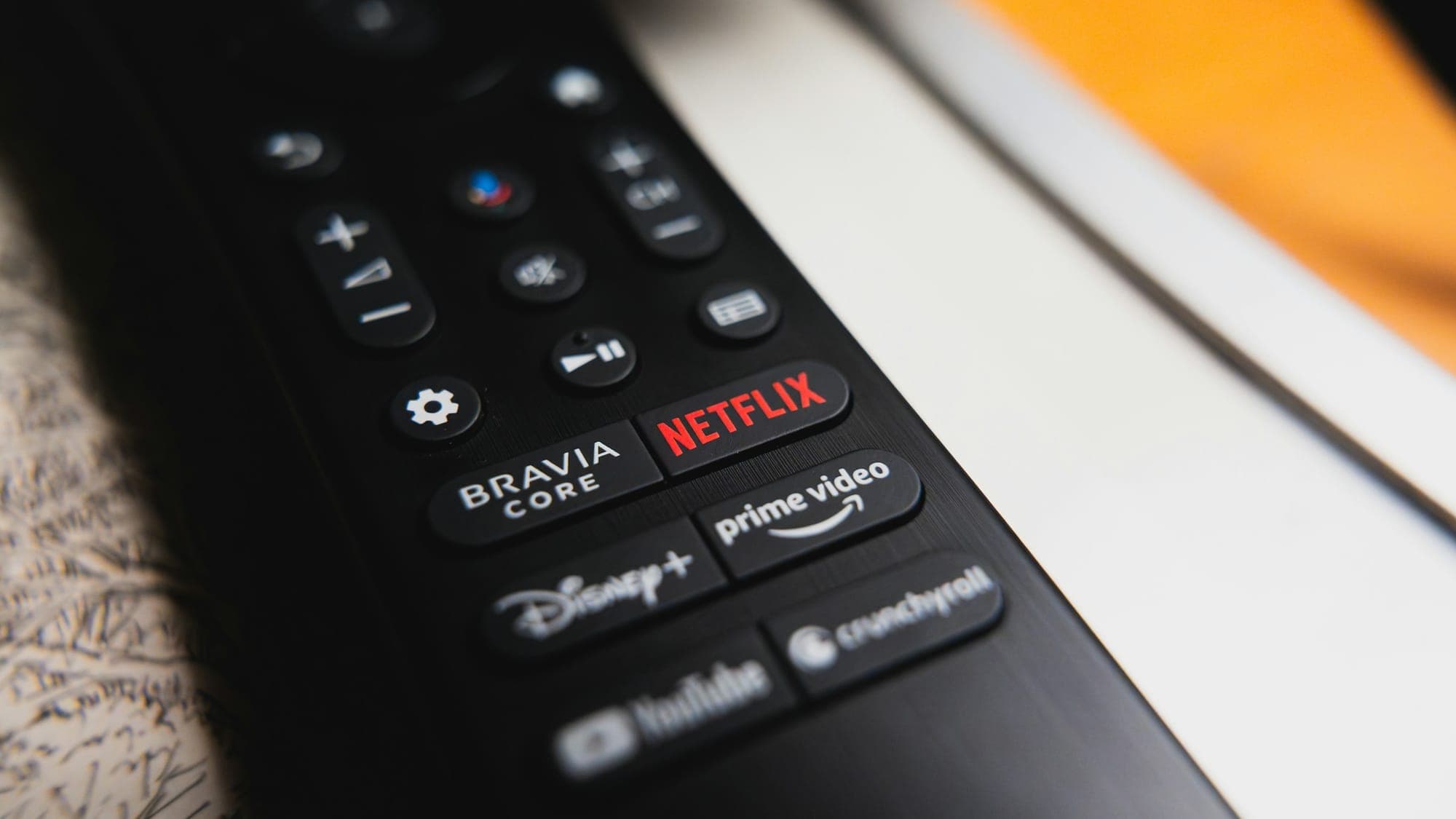 Close-up of a TV remote with dedicated Netflix, Disney+, and Prime Video buttons